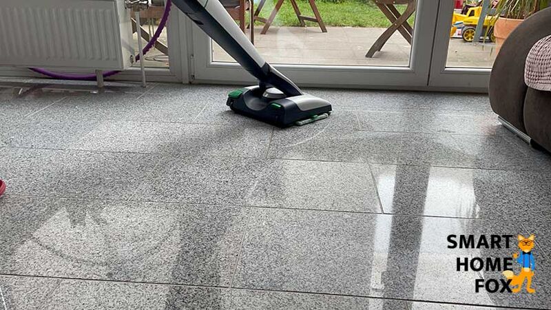 Man sieht, wie der Boden mit dem Vorwerk VB100 mit dem SPB100 Wischaufsatz gereinigt wird.